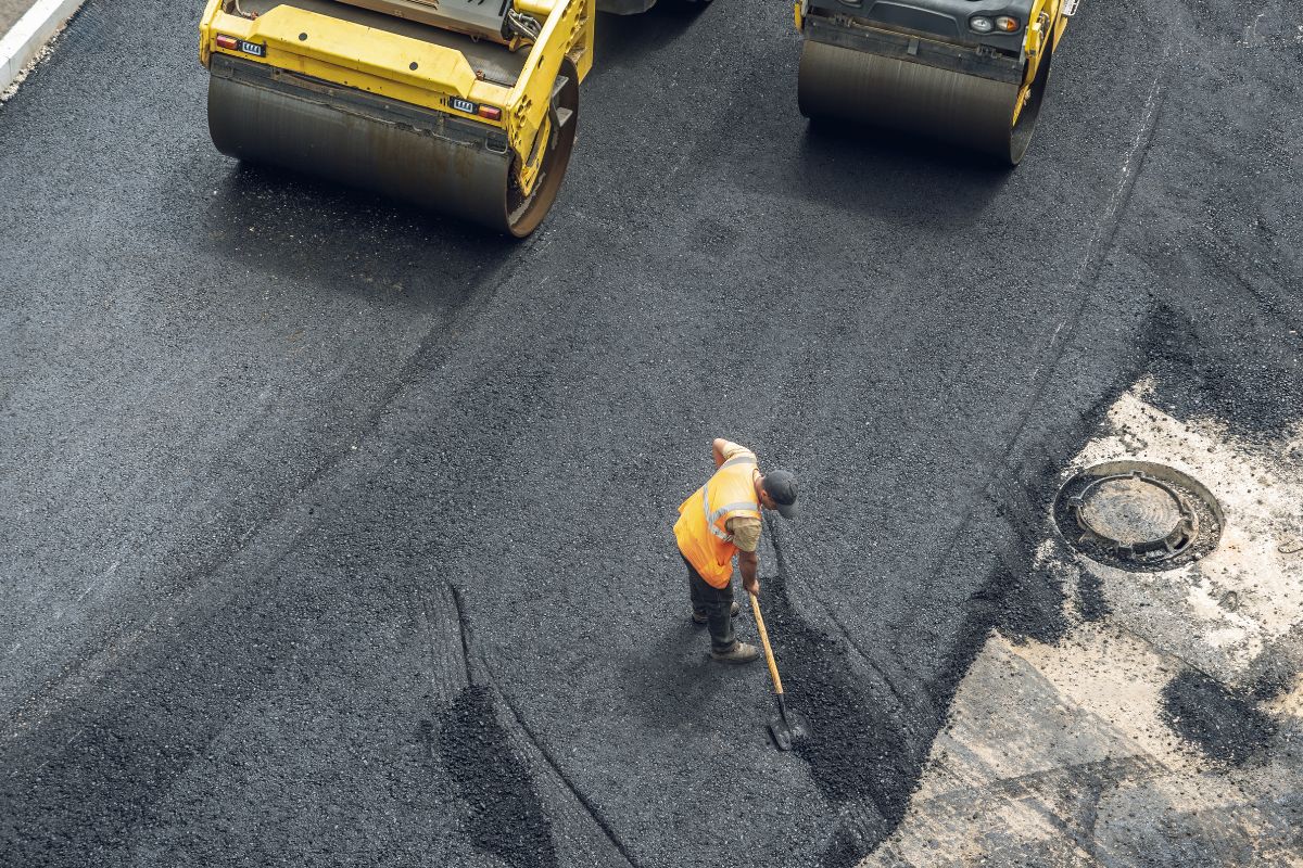 Obra de pavimentación con maquinaria y operario aplicando mecánica de suelos y diseño de pavimentos