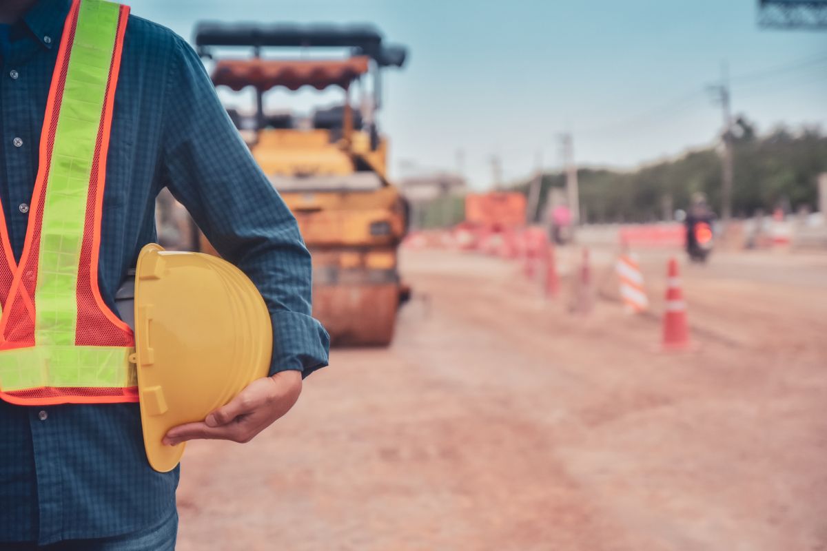 Obra de pavimentación con maquinaria y operario aplicando mecánica de suelos y diseño de pavimentos