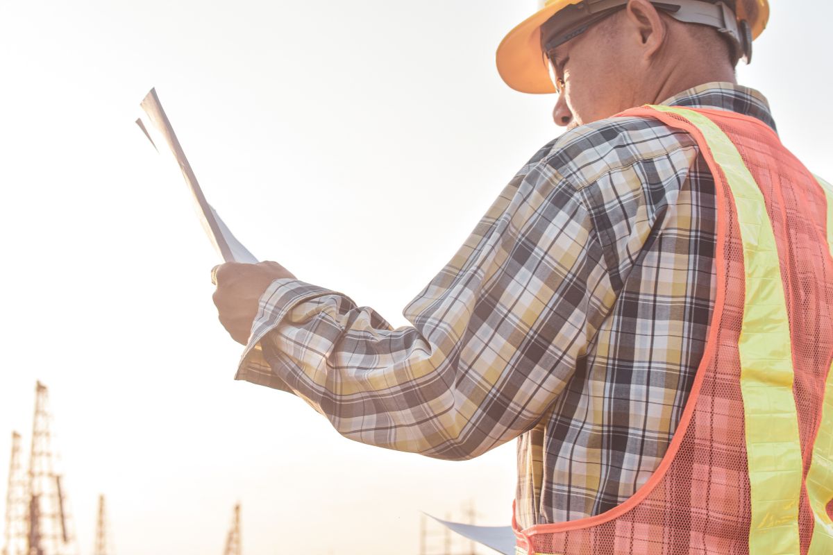 Obra de pavimentación con maquinaria y operario aplicando mecánica de suelos y diseño de pavimentos