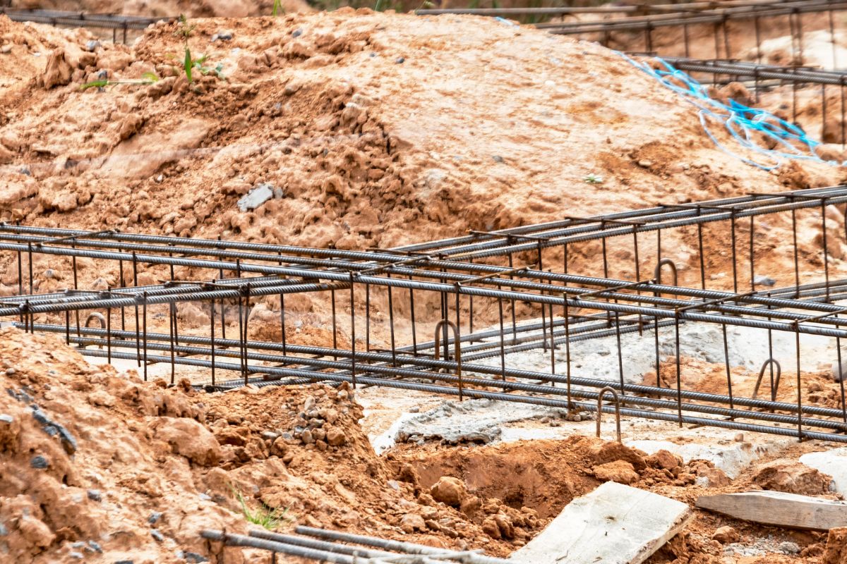Obra de pavimentación con maquinaria y operario aplicando mecánica de suelos y diseño de pavimentos