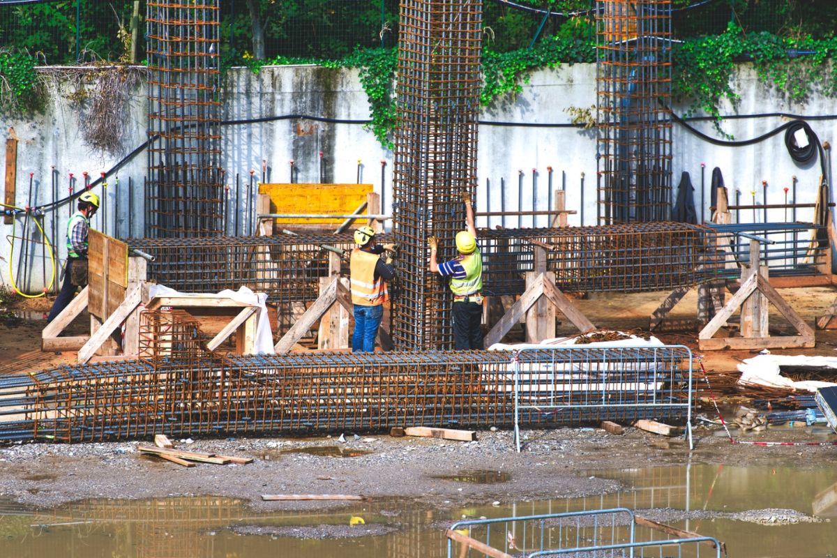 Obra de pavimentación con maquinaria y operario aplicando mecánica de suelos y diseño de pavimentos
