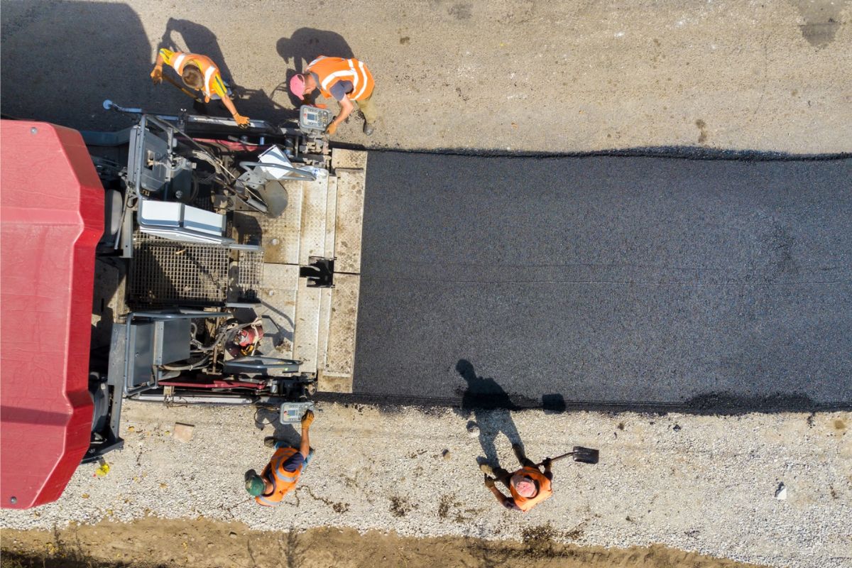 Obra de pavimentación con maquinaria y operario aplicando mecánica de suelos y diseño de pavimentos